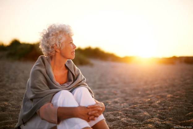 Mature woman on beach looking into horizon